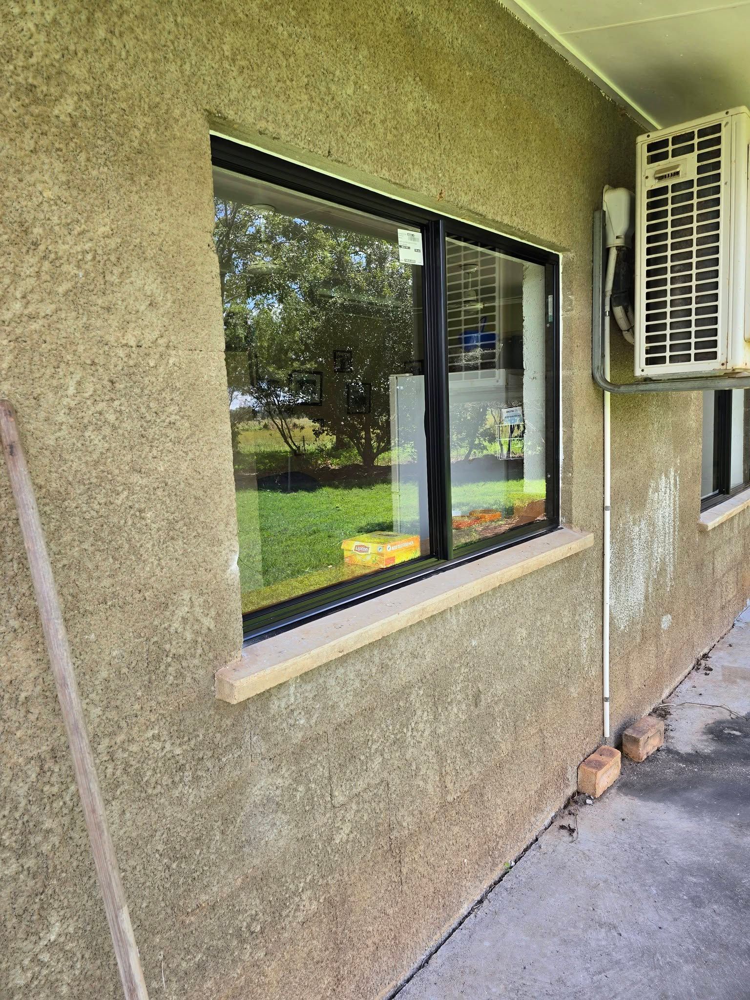 Exterior Wall with A Black-Framed Window and Air Conditioner Unit — Sun Co Concrete And Construction in Dimbulah, QLD