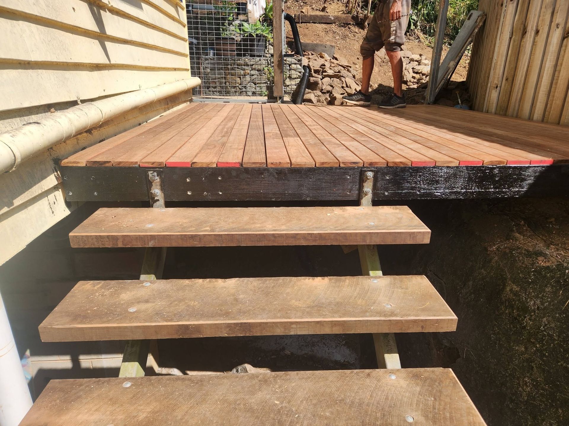 Wooden Steps Leading to A Newly Raised Deck Beside a House — Sun Co Concrete And Construction in Tablelands, QLD