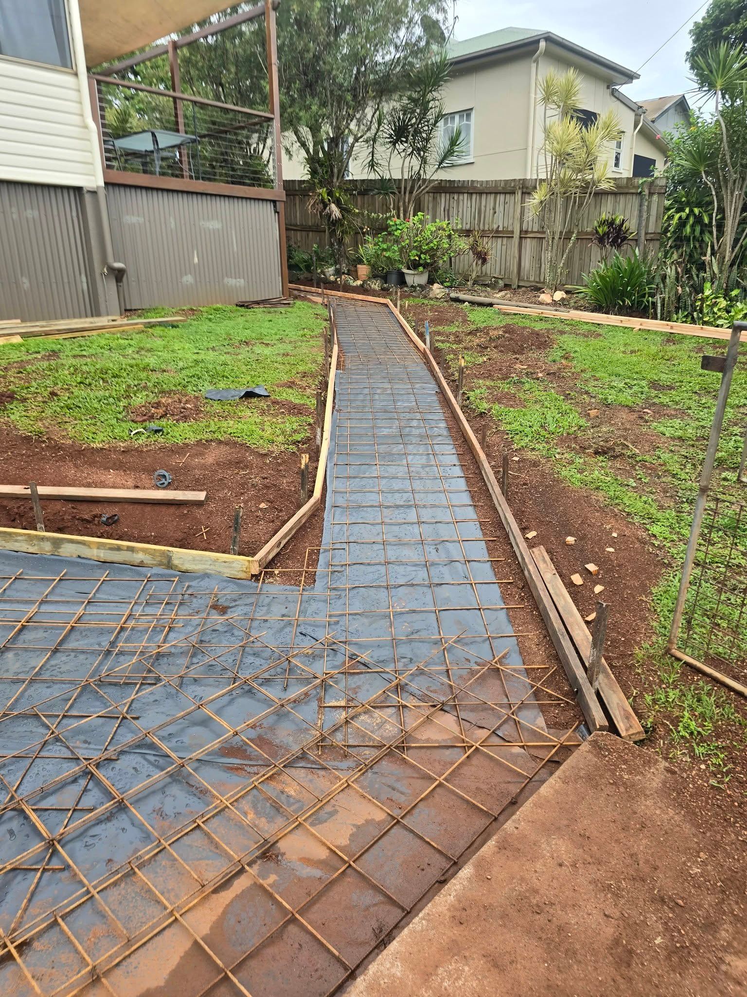 Garden Path Under Construction with Blue Pavers and Exposed Rebar — Sun Co Concrete And Construction in Dimbulah, QLD