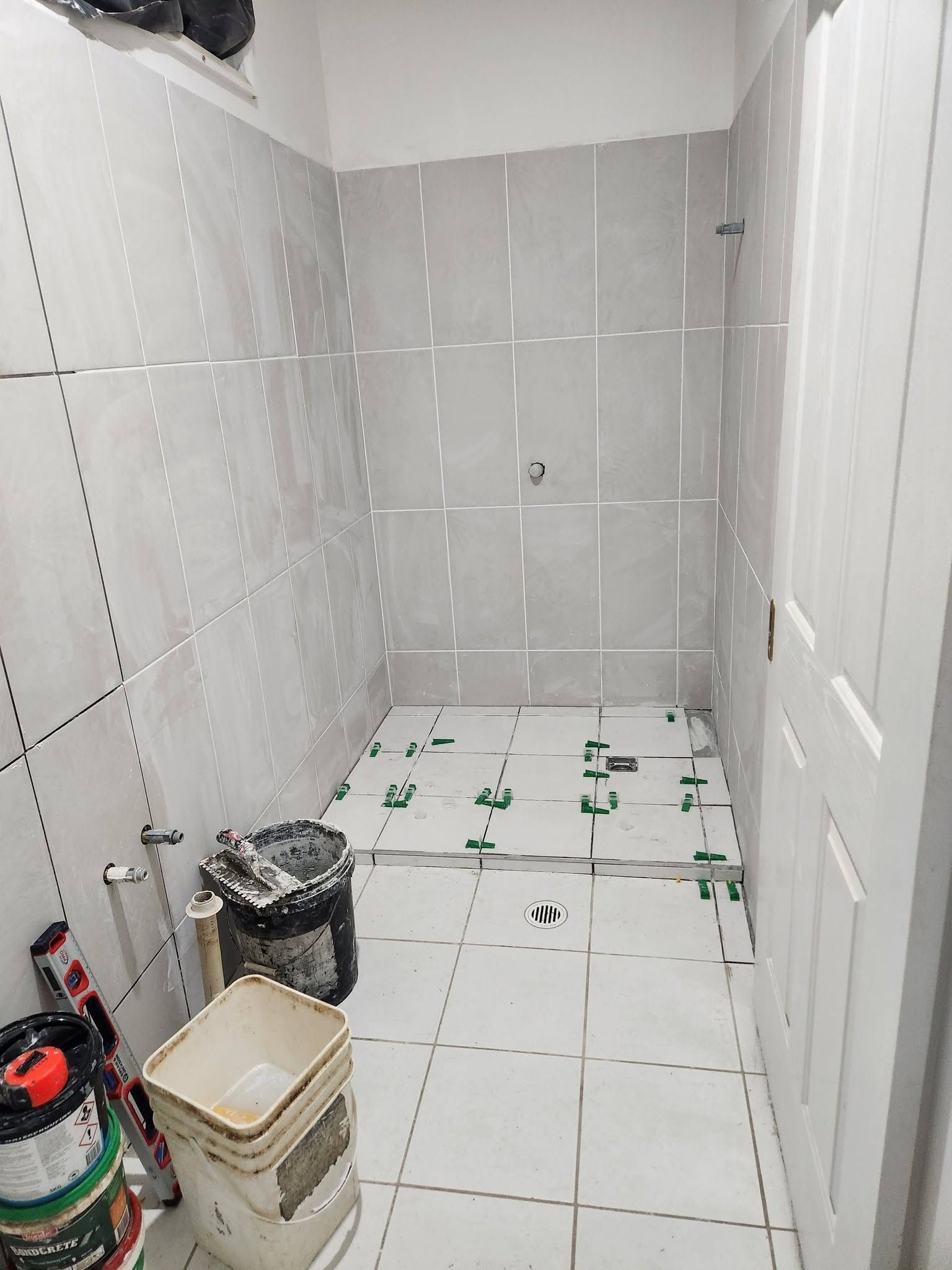 Partially Tiled Bathroom Under Renovation, with Tools and Buckets — Sun Co Concrete And Construction in Dimbulah, QLD