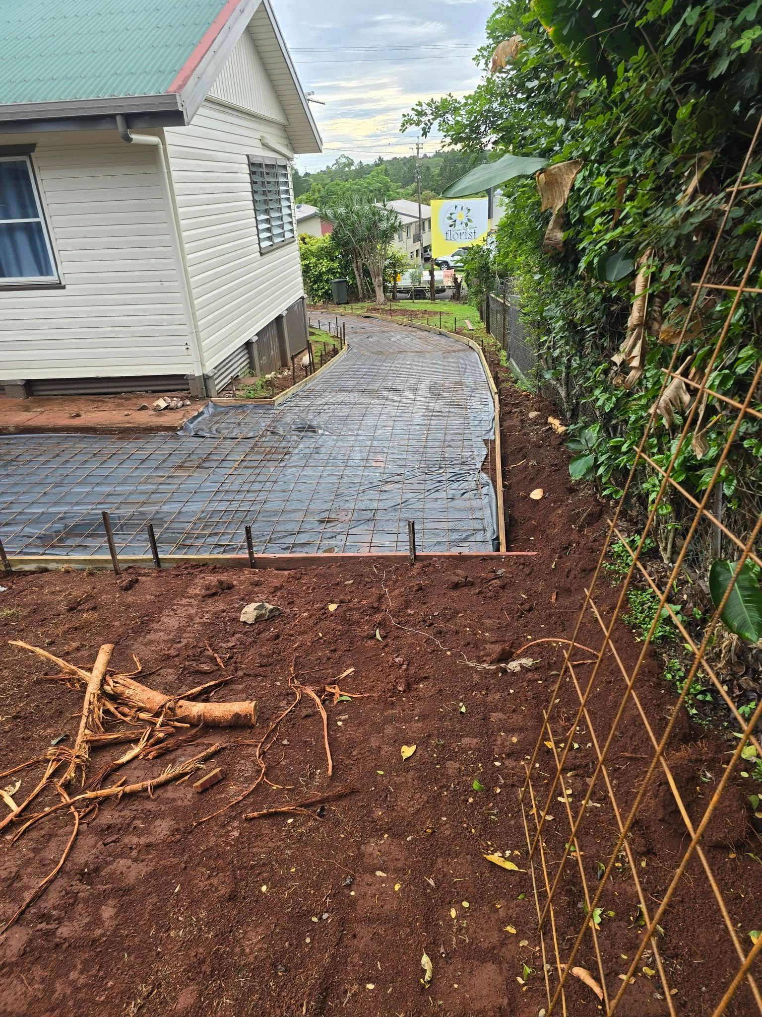 Concrete Path Under Construction Beside a White House — Sun Co Concrete And Construction in Tablelands, QLD