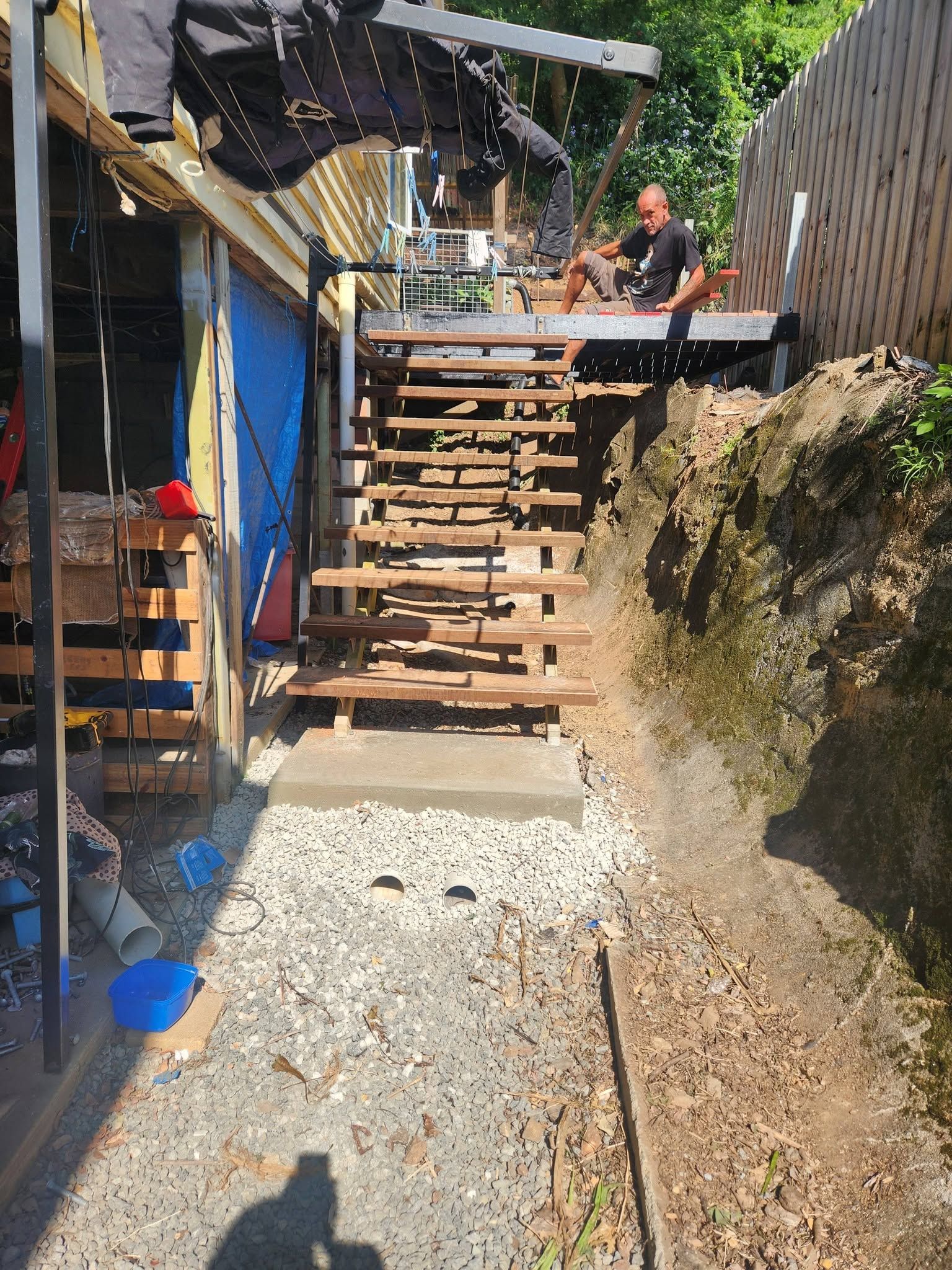 Steep Outdoor Wooden Staircase Beside a Gravel Path, with Two People — Sun Co Concrete And Construction in Dimbulah, QLD