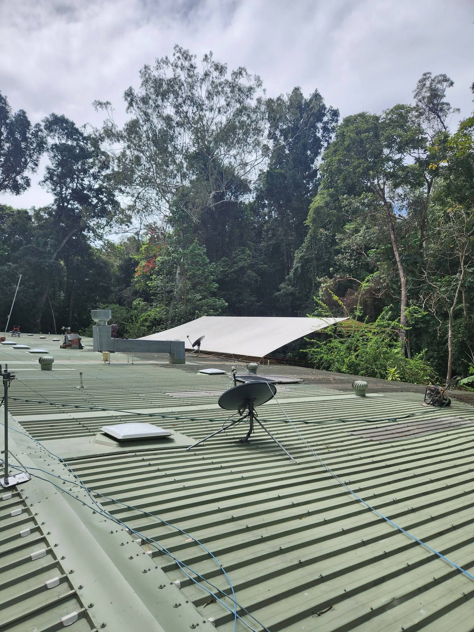 Rooftop with Green Corrugated Metal, Satellite Dishes — Sun Co Concrete And Construction in Atherton, QLD