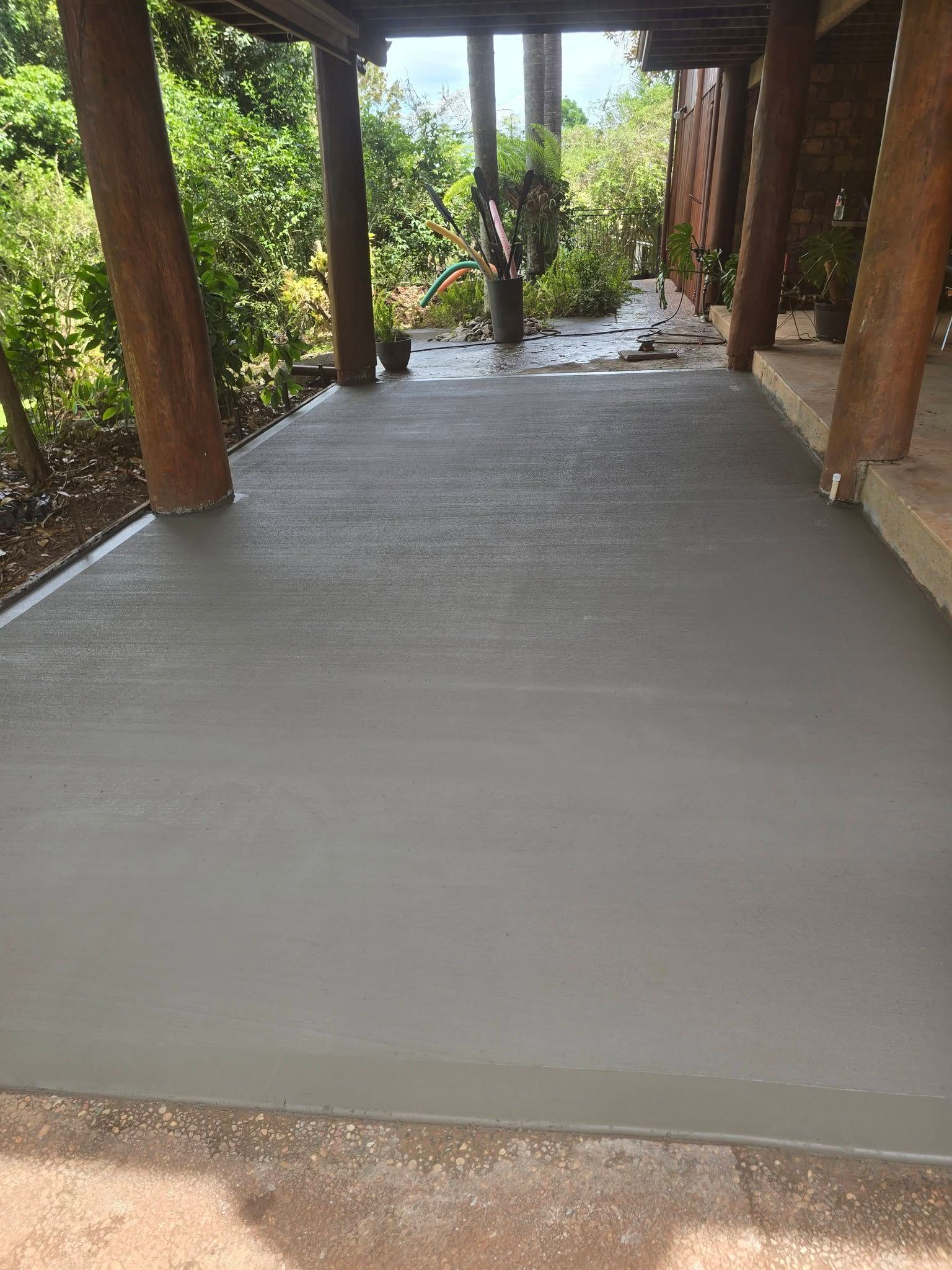 Freshly Poured Gray Concrete Floor Under a Covered Outdoor Structure — Sun Co Concrete And Construction in Dimbulah, QLD