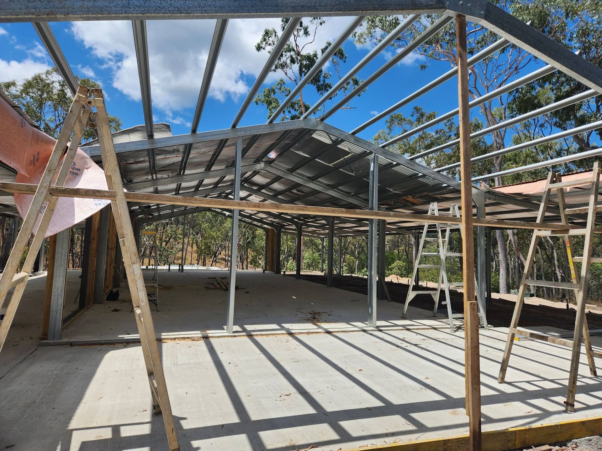 Partially Built House Frame with Metal Roof Trusses — Sun Co Concrete And Construction in Cairns, QLD