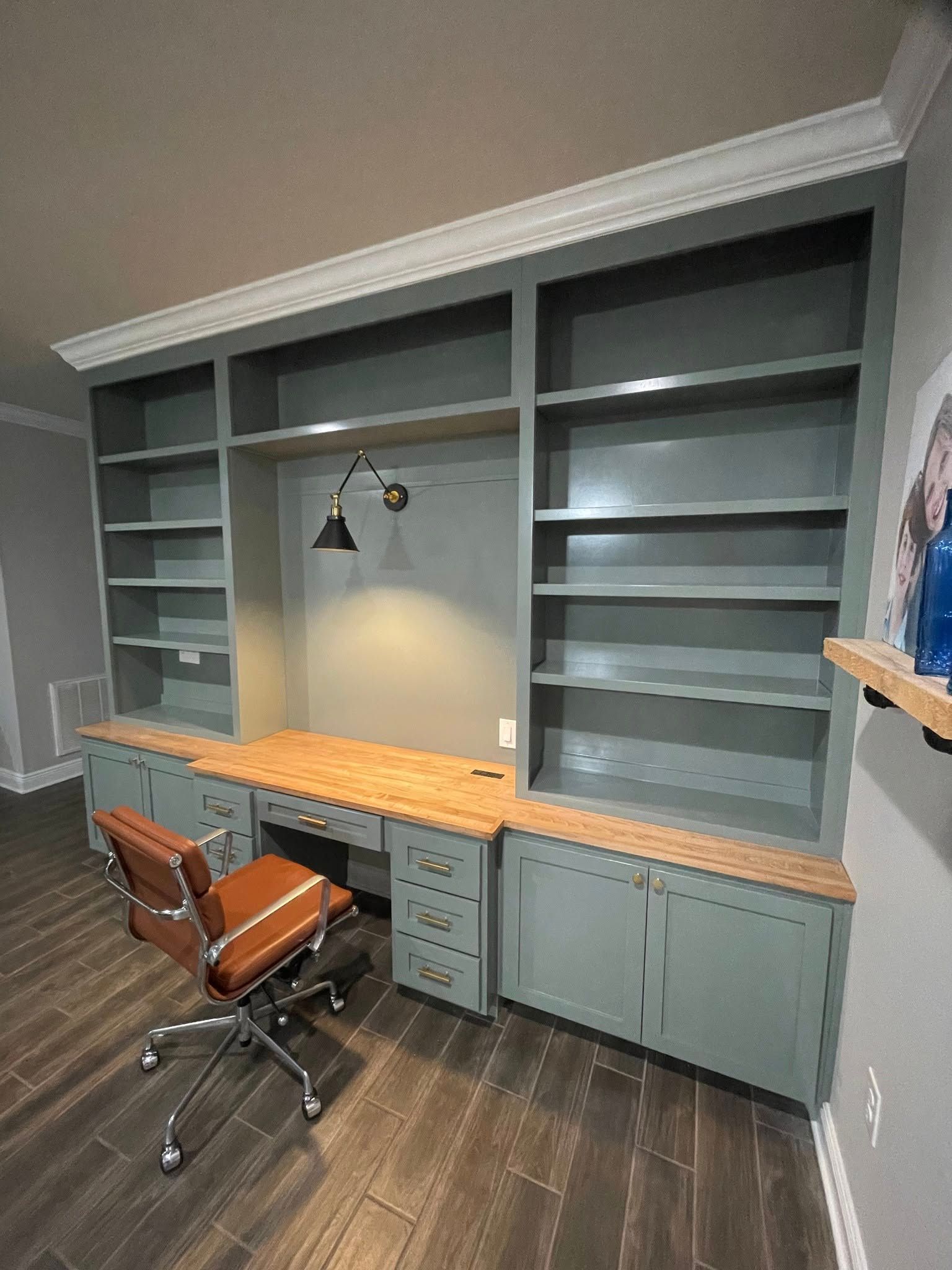 Close-up of light wood kitchen cabinets featuring recessed panels and horizontal matte black bar pulls.