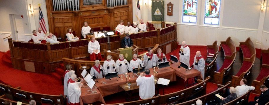 First Presbyterian Church Rock Hill Hand Bell members in robes and red stoles in the Sanctuary leading in worship..
