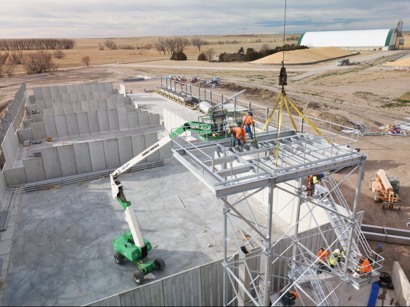 A group of construction workers are standing on top of a building under construction.