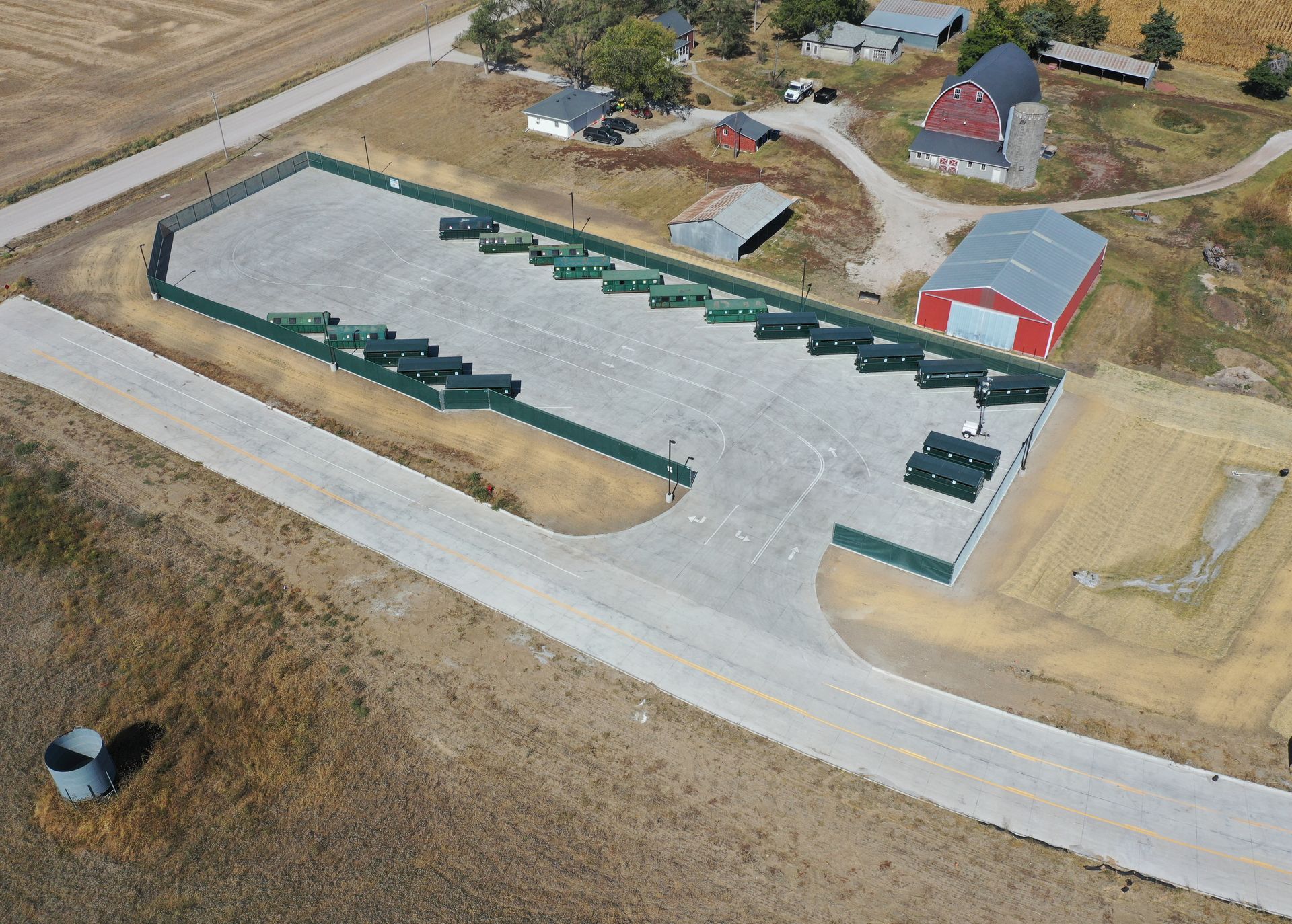 An aerial view of a farm with a red barn in the background