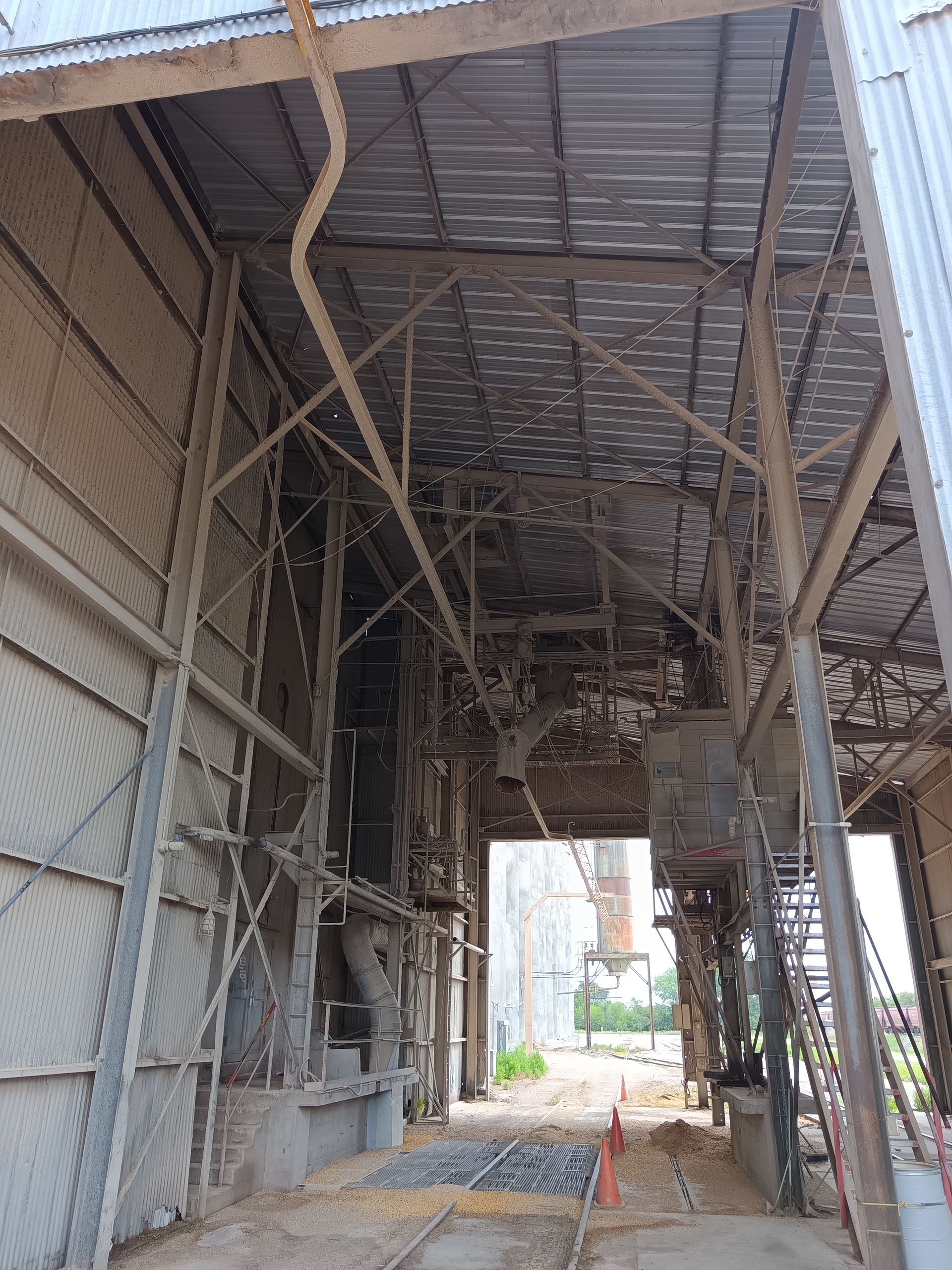 A large building with a metal roof and stairs leading up to it.