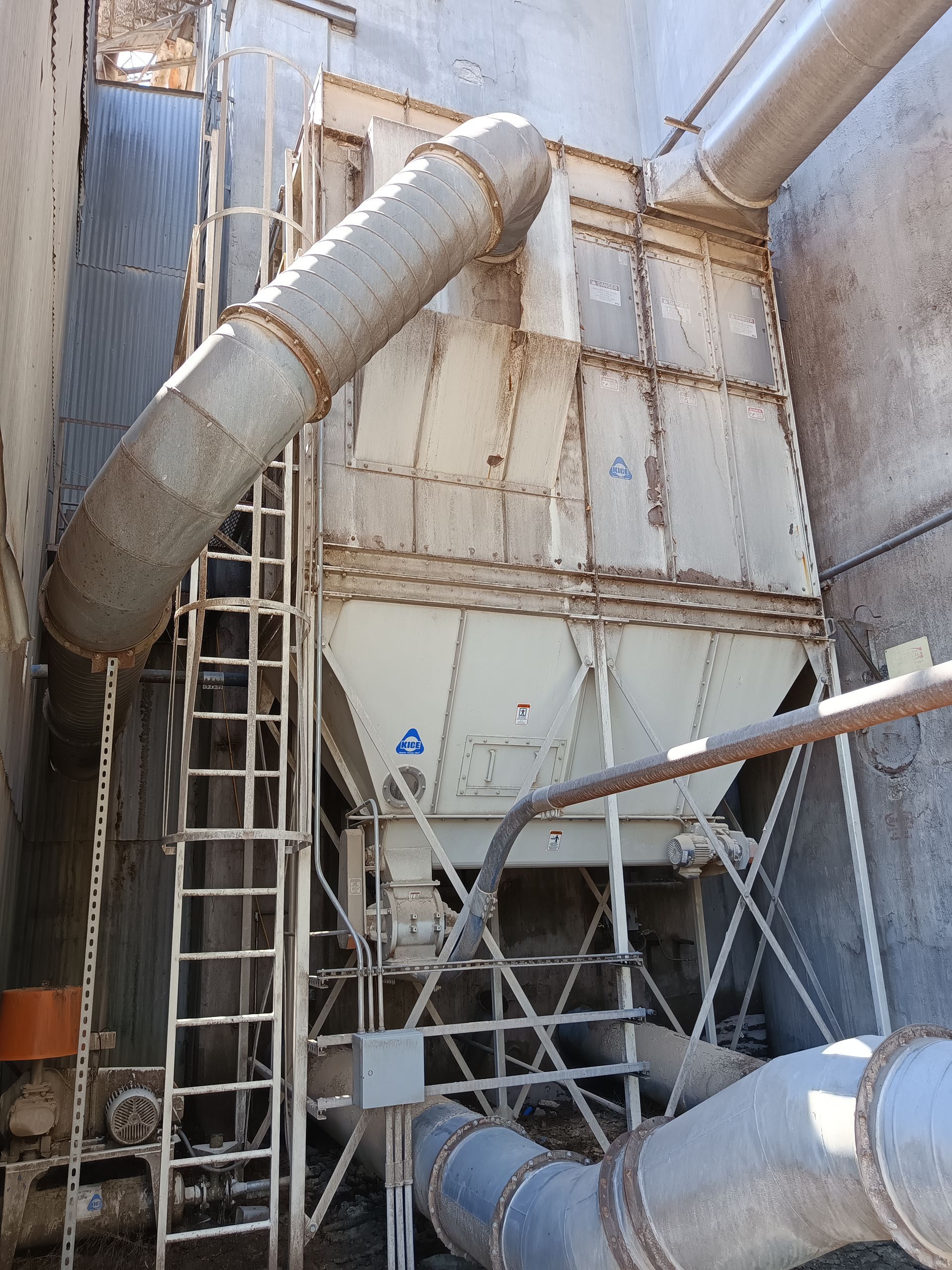 A staircase leading up to a large container with pipes coming out of it