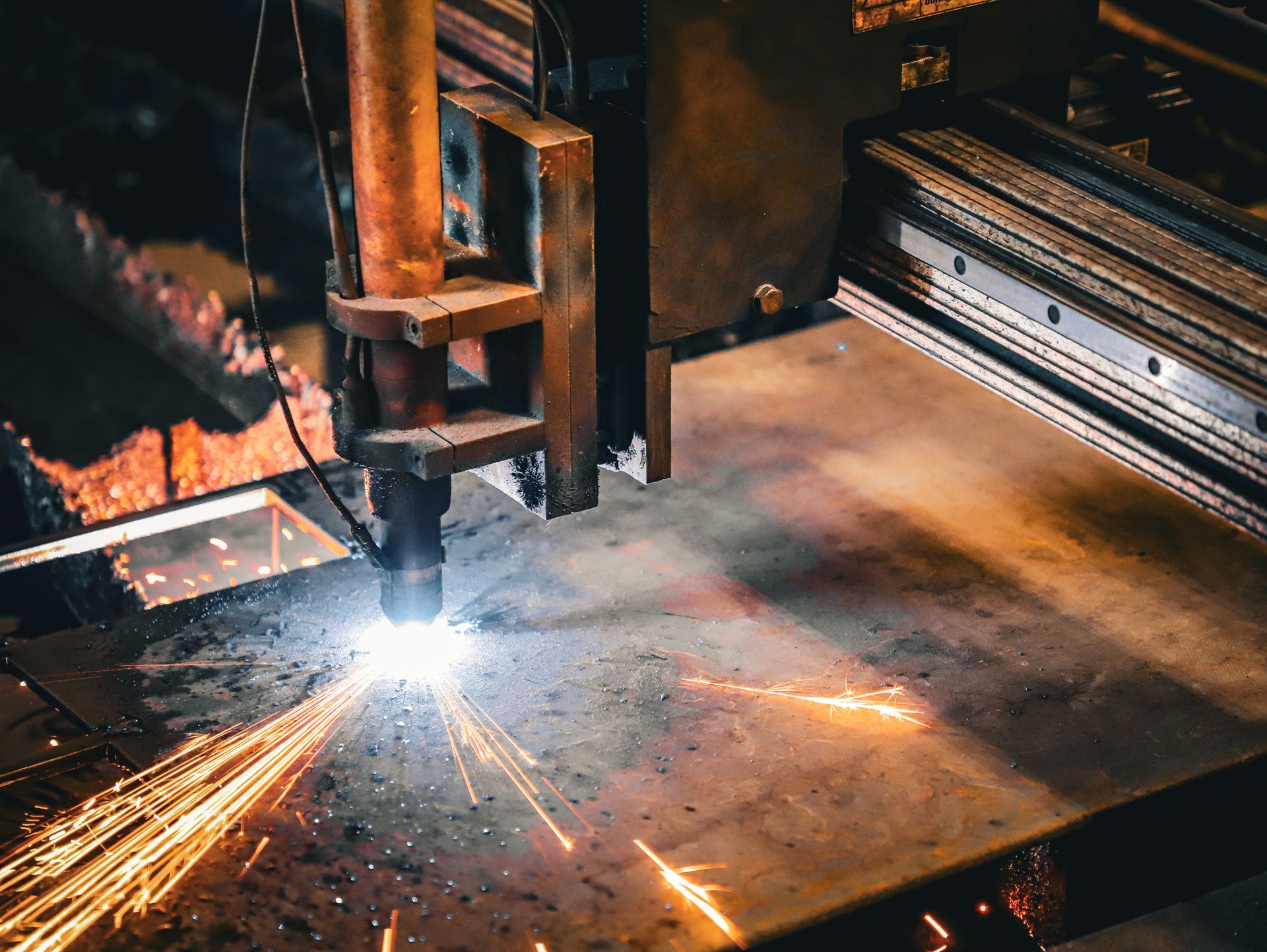 A machine is cutting a piece of metal with sparks coming out of it.