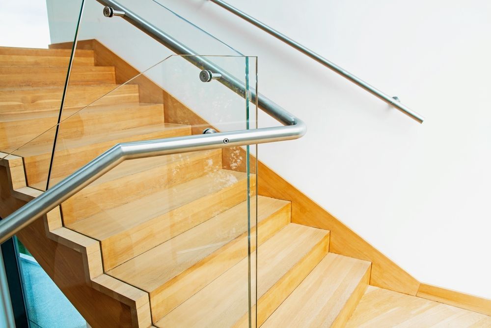 A Wooden Staircase With a Glass Railing and a Stainless Steel Railing — Sun City Sheetmetal In Garbutt, QLD