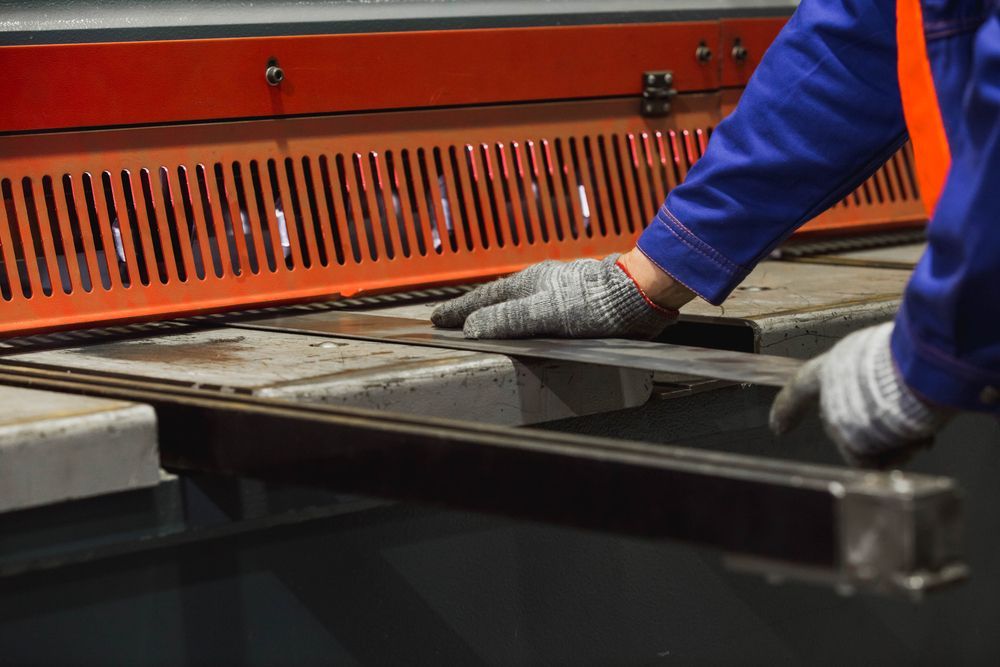 A Person is Cutting a Piece of Metal on a Machine — Sun City Sheetmetal In Garbutt, QLD