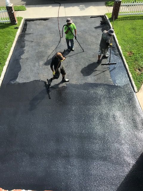 A group of people are working on a driveway.