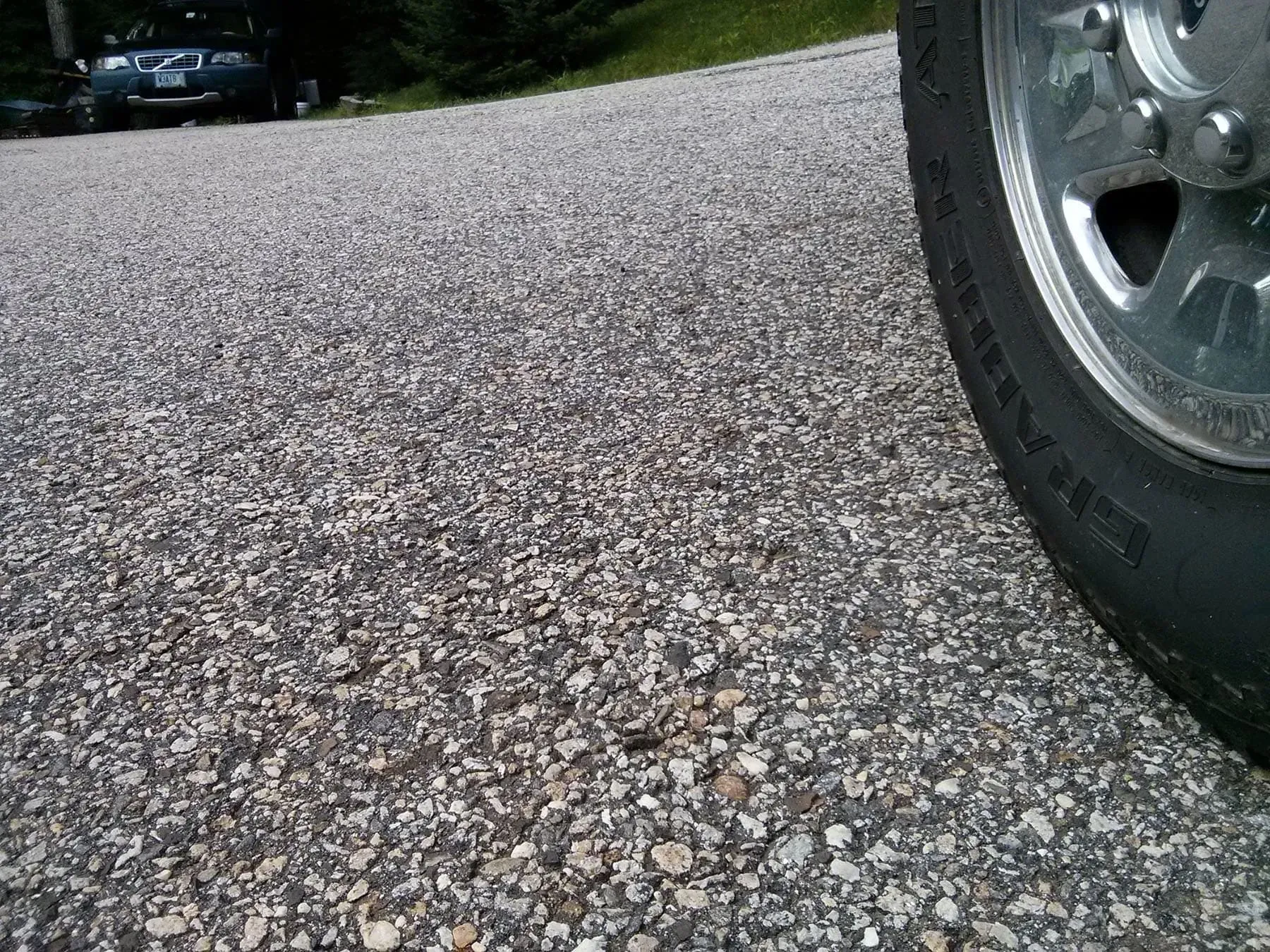 A close up of a tire on a gravel road. A close up of a tire on a gravel road.