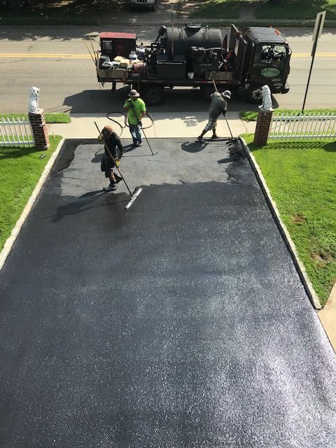 A group of people are working on a driveway.