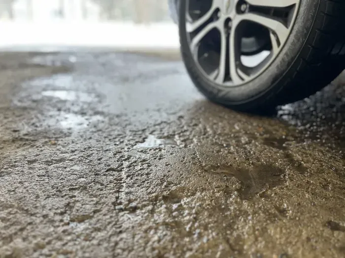 A close up of a car wheel on a muddy road. A close up of a car wheel on a muddy road.