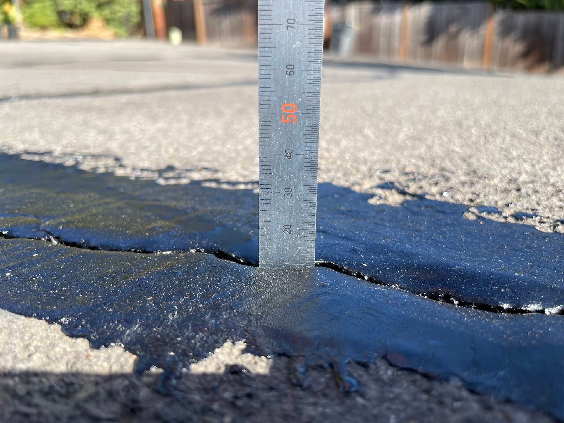 A ruler being used to check asphalt. A ruler being used to check asphalt.
