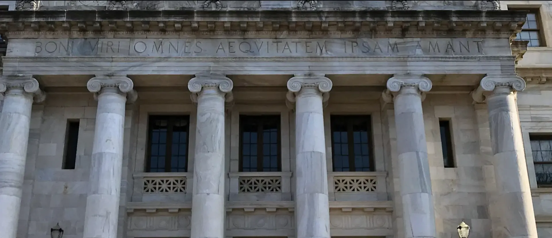 A large building with columns and a statue on the front