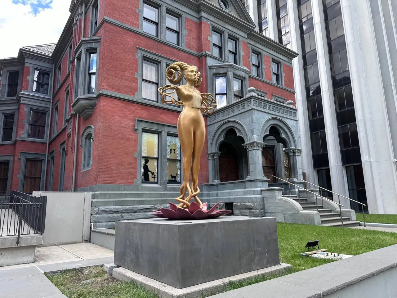 A golden statue on display in front of the Newark museum of art. A golden statue on display in front of the Newark museum of art.