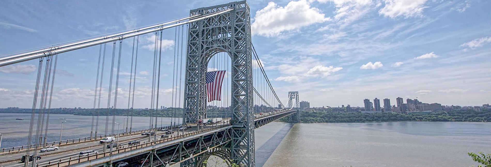 A bridge over a body of water with a city in the background.