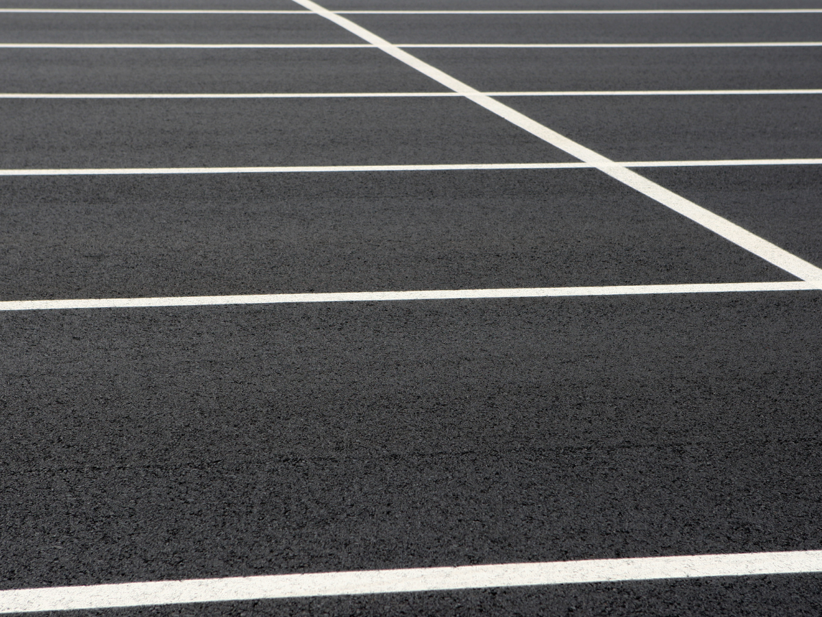 A close up of a parking lot with white lines on it. A close up of a parking lot with white lines on it.