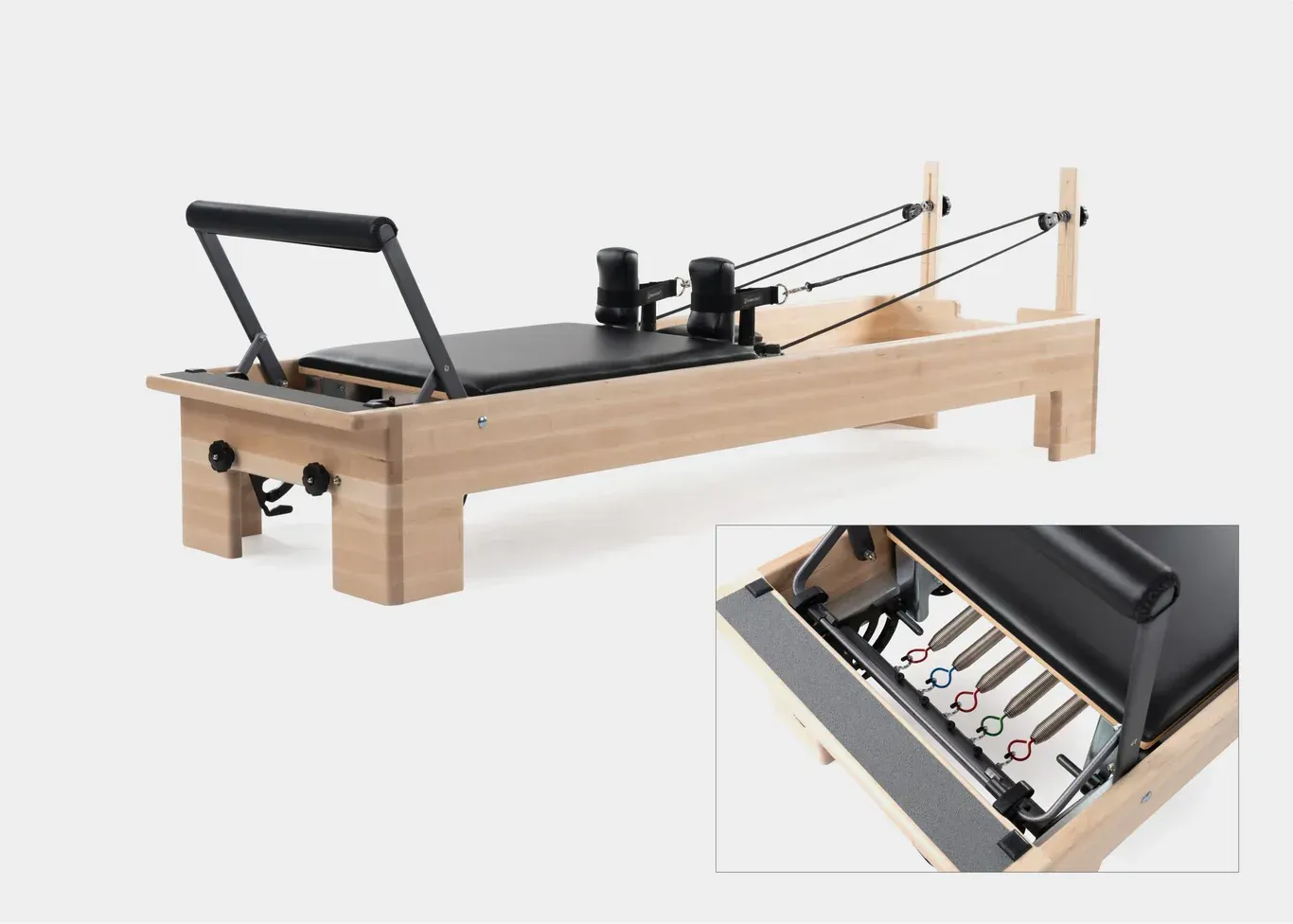 Pilates reformer machine with close-up detail of the footbar and carriage