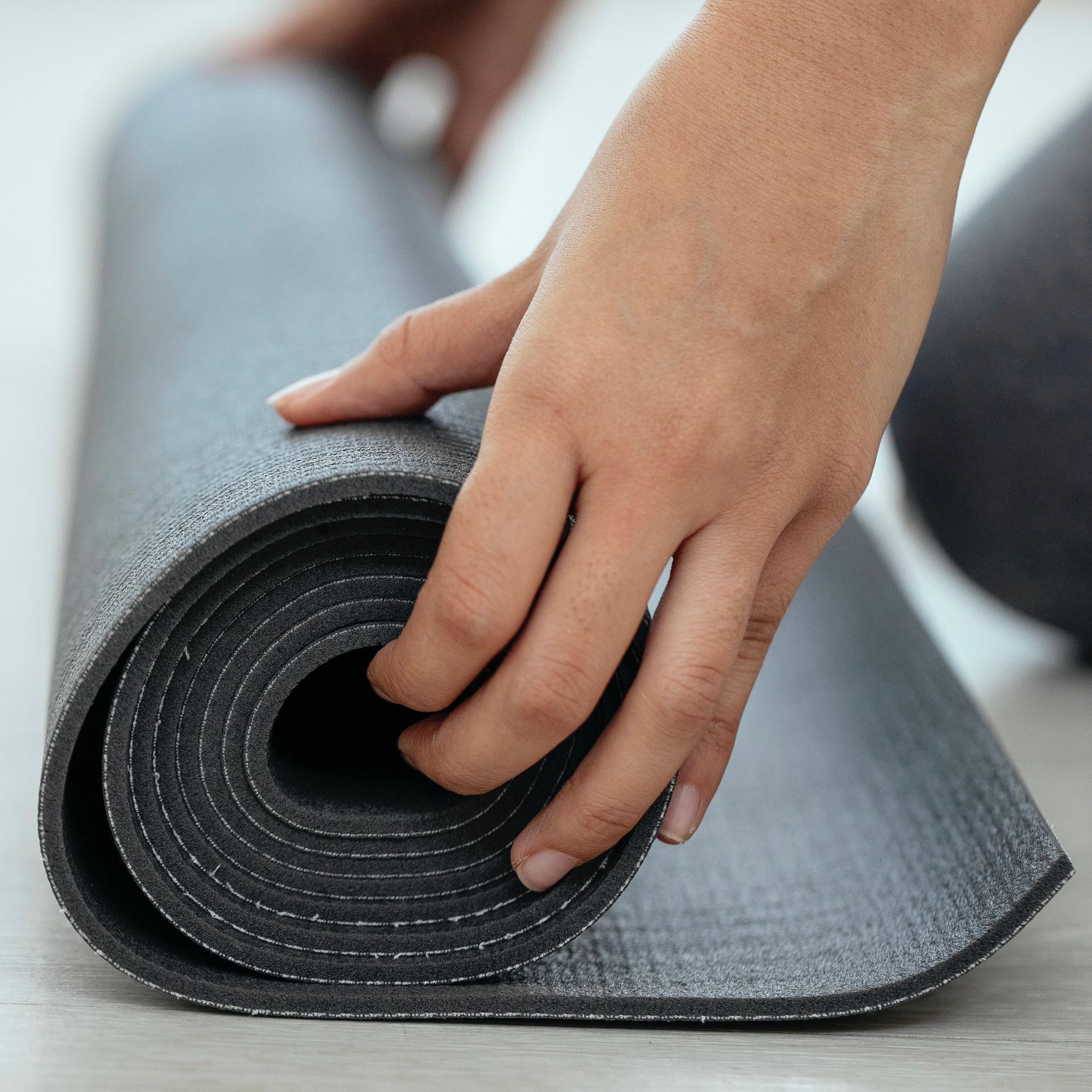 Close up of a hand rolling a yoga mat