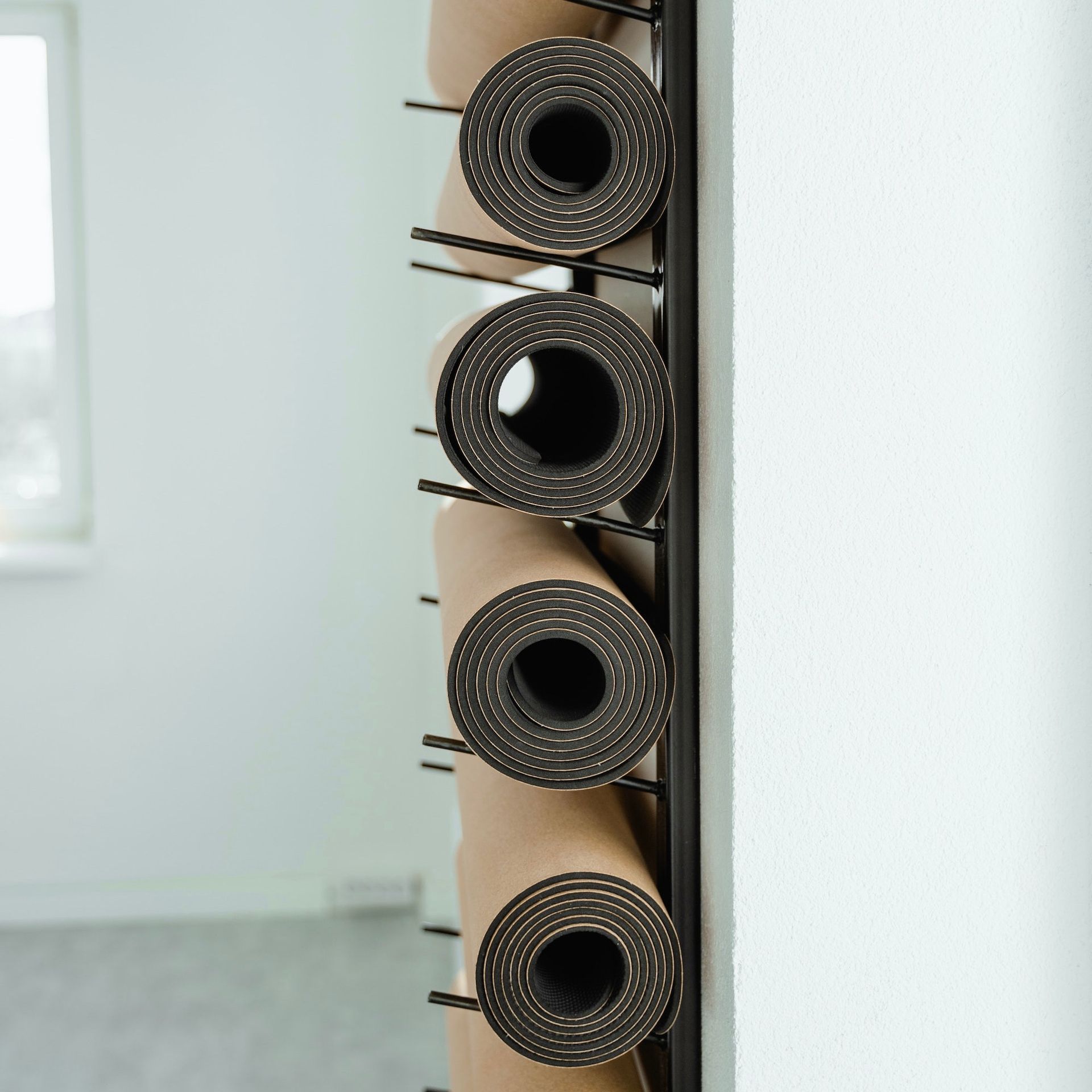 Yoga mat storage rack with rolled mats