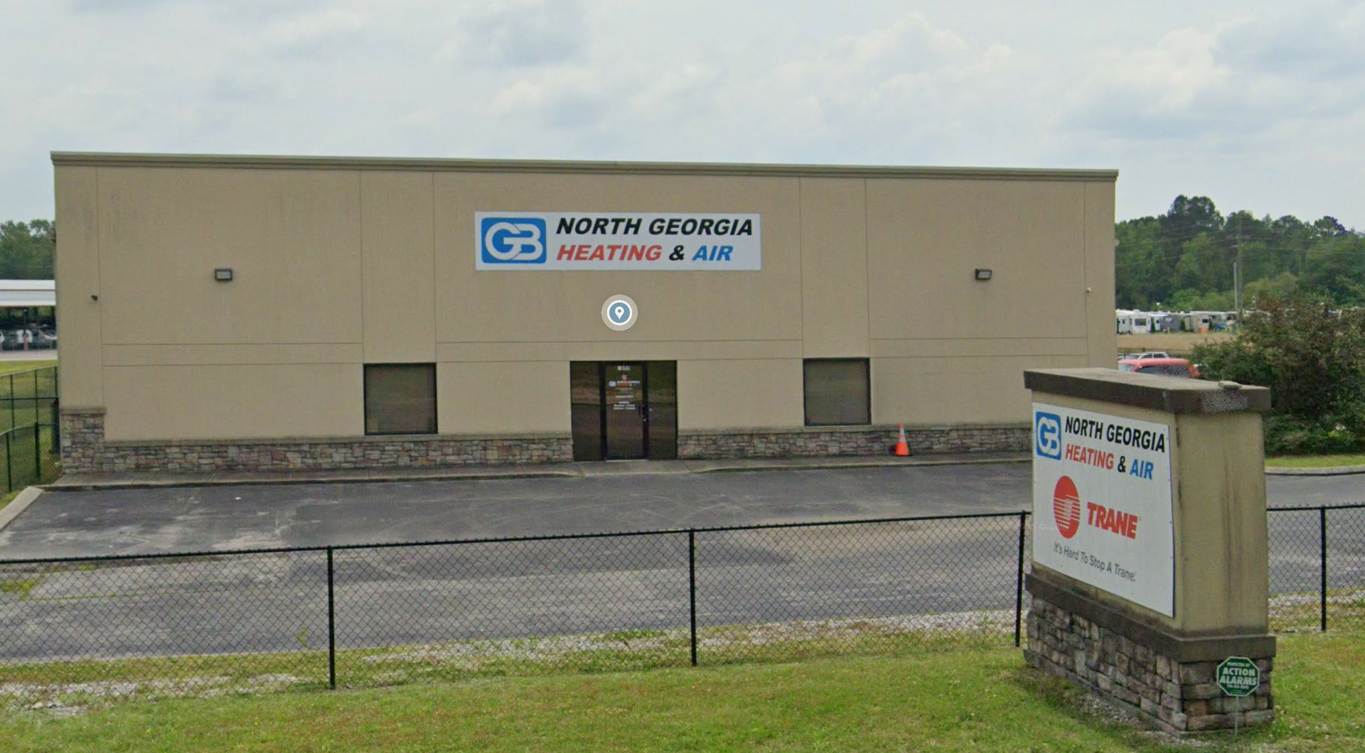 Tan, single-story commercial building with North Georgia Heating & Air signage and a matching roadside monument sign.