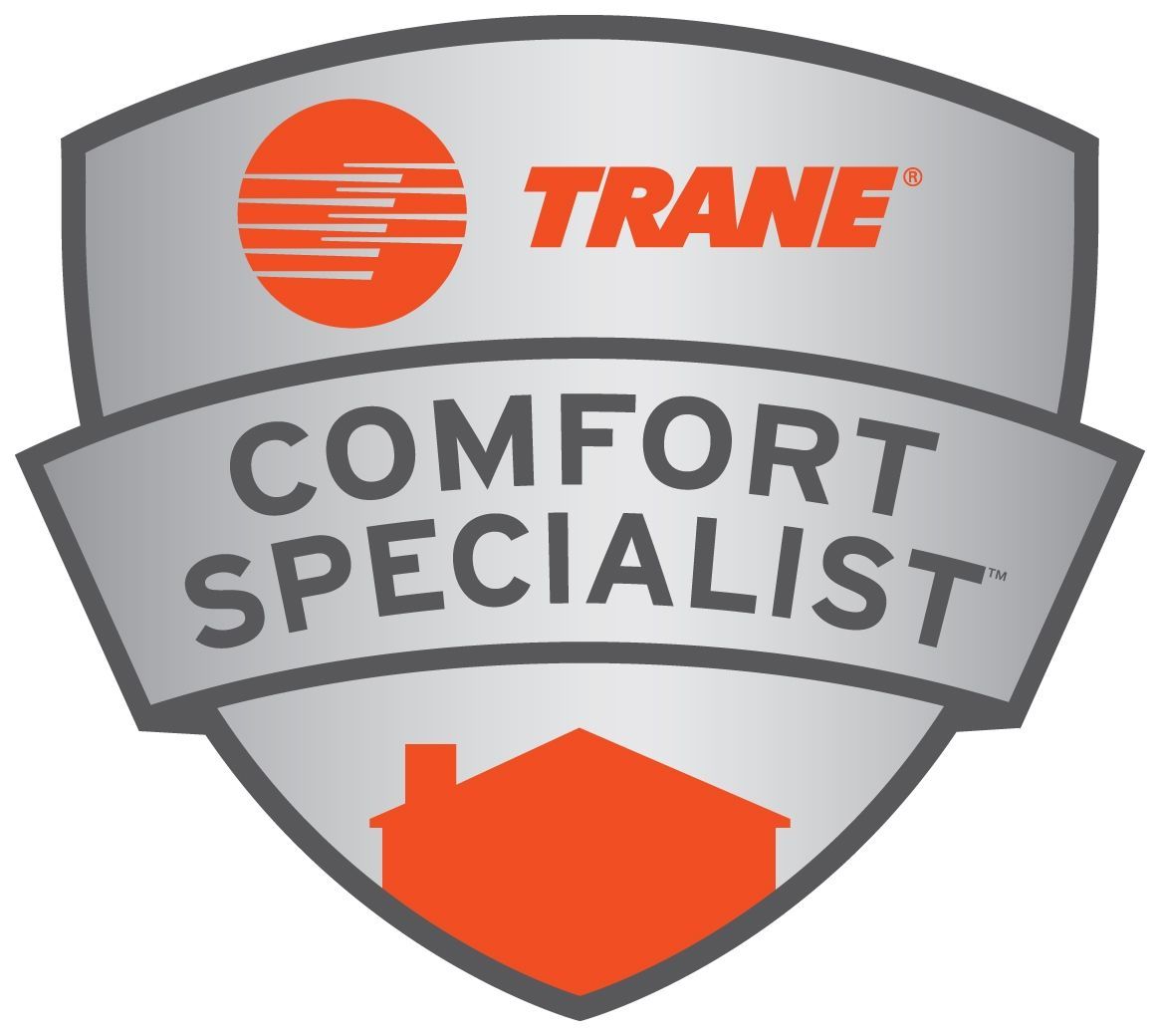 Silver shield logo with the orange Trane logo, the text "COMFORT SPECIALIST," and an orange house silhouette at the bottom.