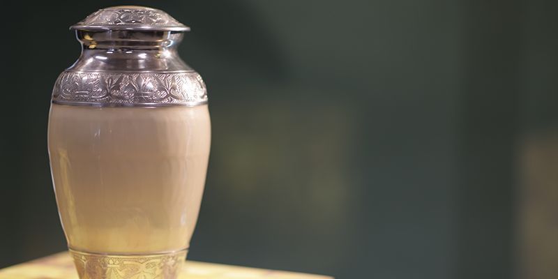 A urn filled with ashes is sitting on a table.