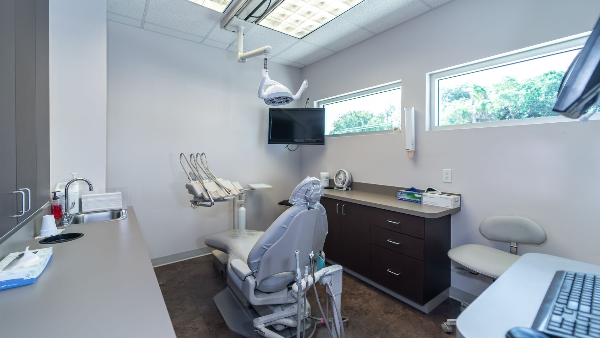 A dental office with a dental chair and a desk.
