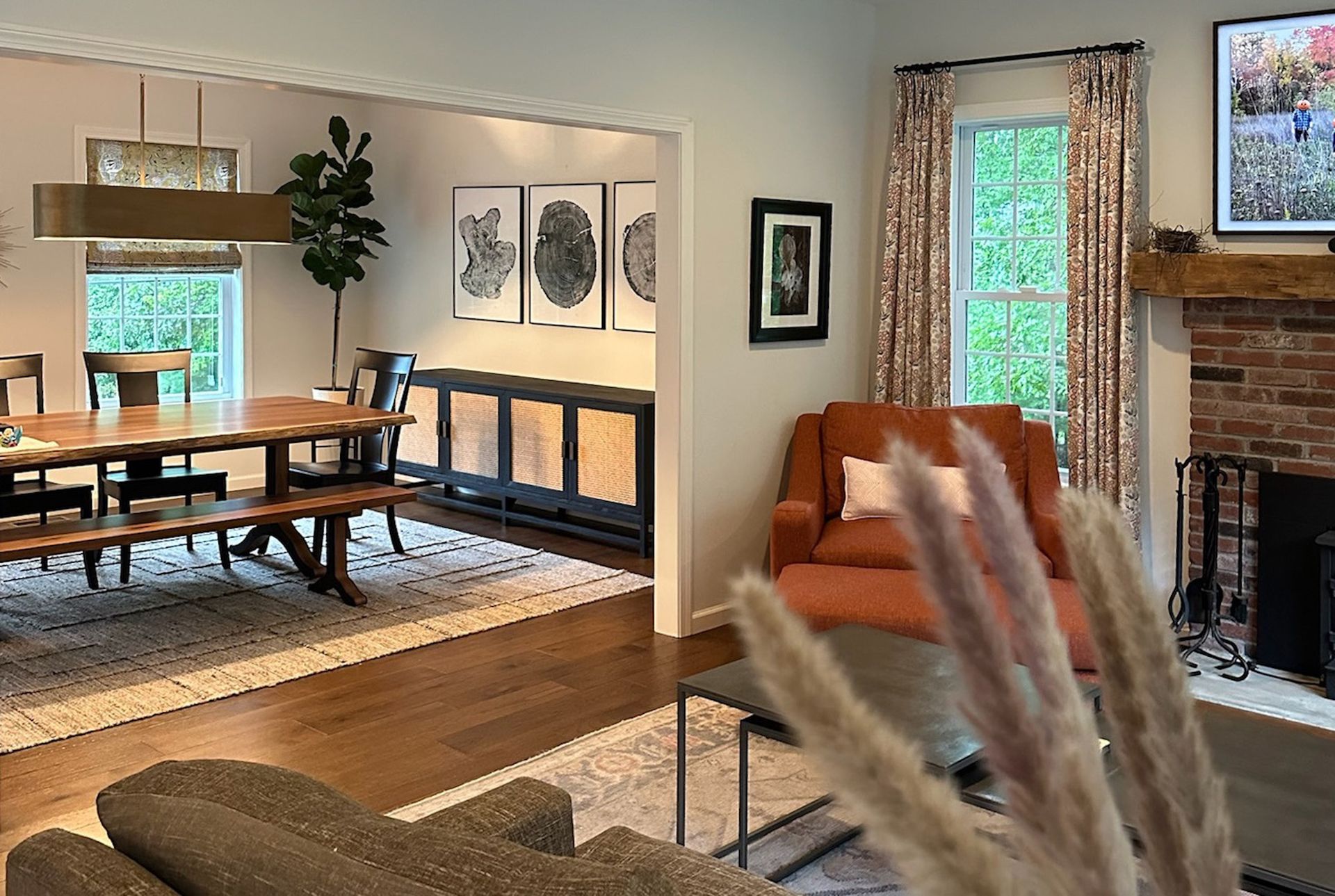 Spacious living room with dining area. Dining table, buffet, and fireplace in a home setting.