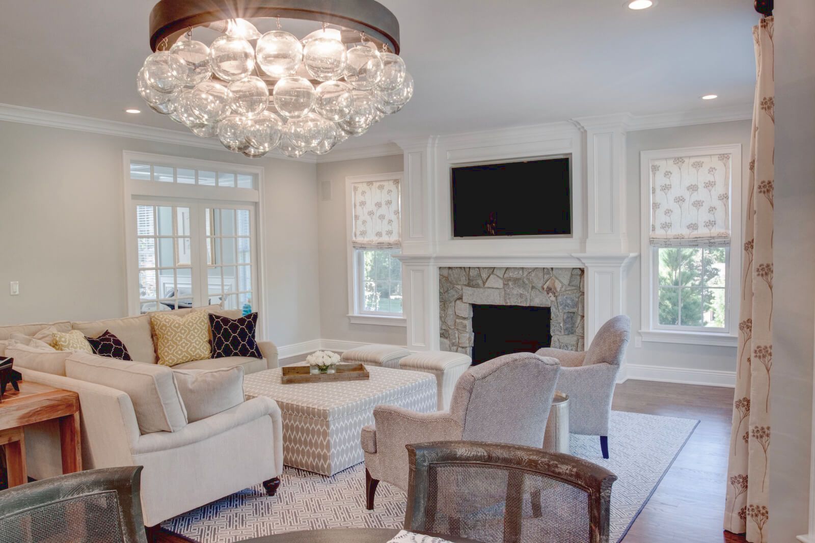 Living room with sectional sofa, fireplace, and large crystal chandelier.