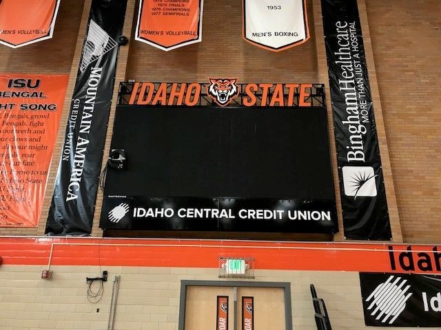 Scoreboard at Idaho State University, with logos for sponsors, and banners.