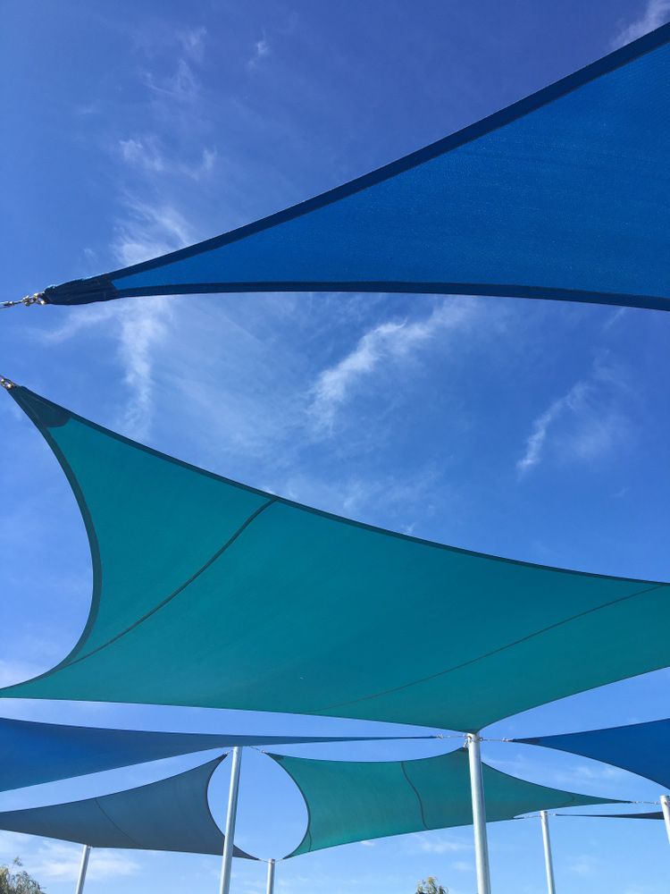 A Group Of Blue Umbrellas Against A Blue Sky — Gaeta's Upholstery Blinds & Awnings in Grafton, NSW