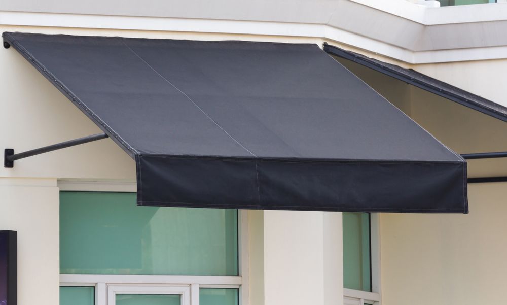A Black Awning Is On The Side Of A Building — Gaeta's Upholstery Blinds & Awnings in Grafton, NSW