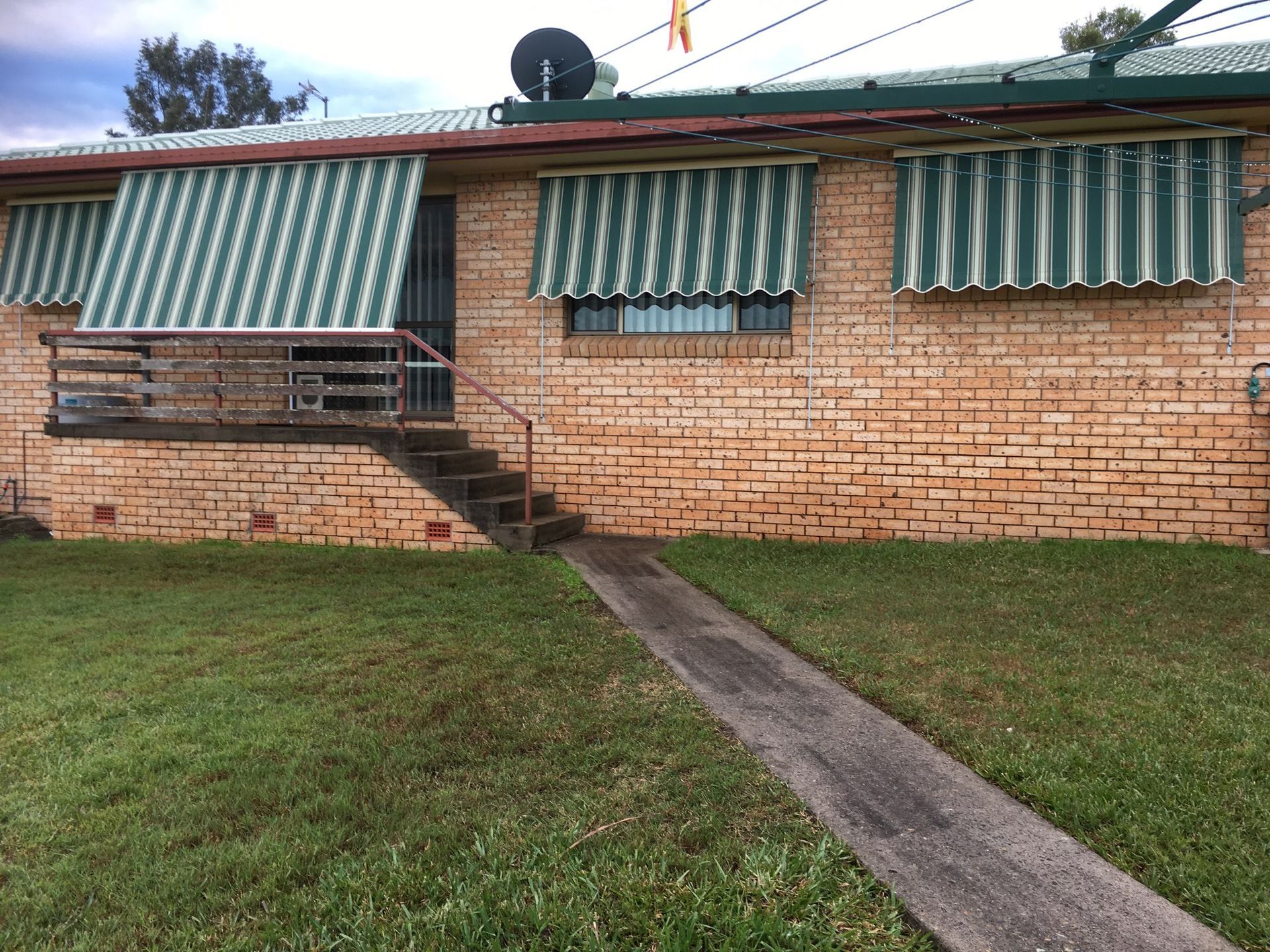 A Red And White Striped Awning Over A Doorway — Gaeta's Upholstery Blinds & Awnings in Grafton, NSW