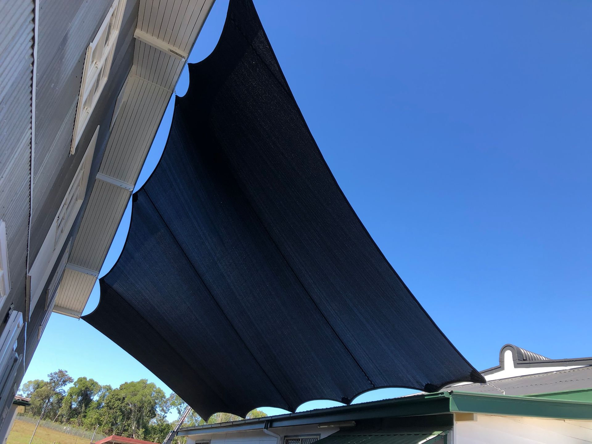 A Group Of Umbrellas Are Sitting On Top Of A Brick Pavement In A Park — Gaeta's Upholstery Blinds & Awnings in Grafton, NSW