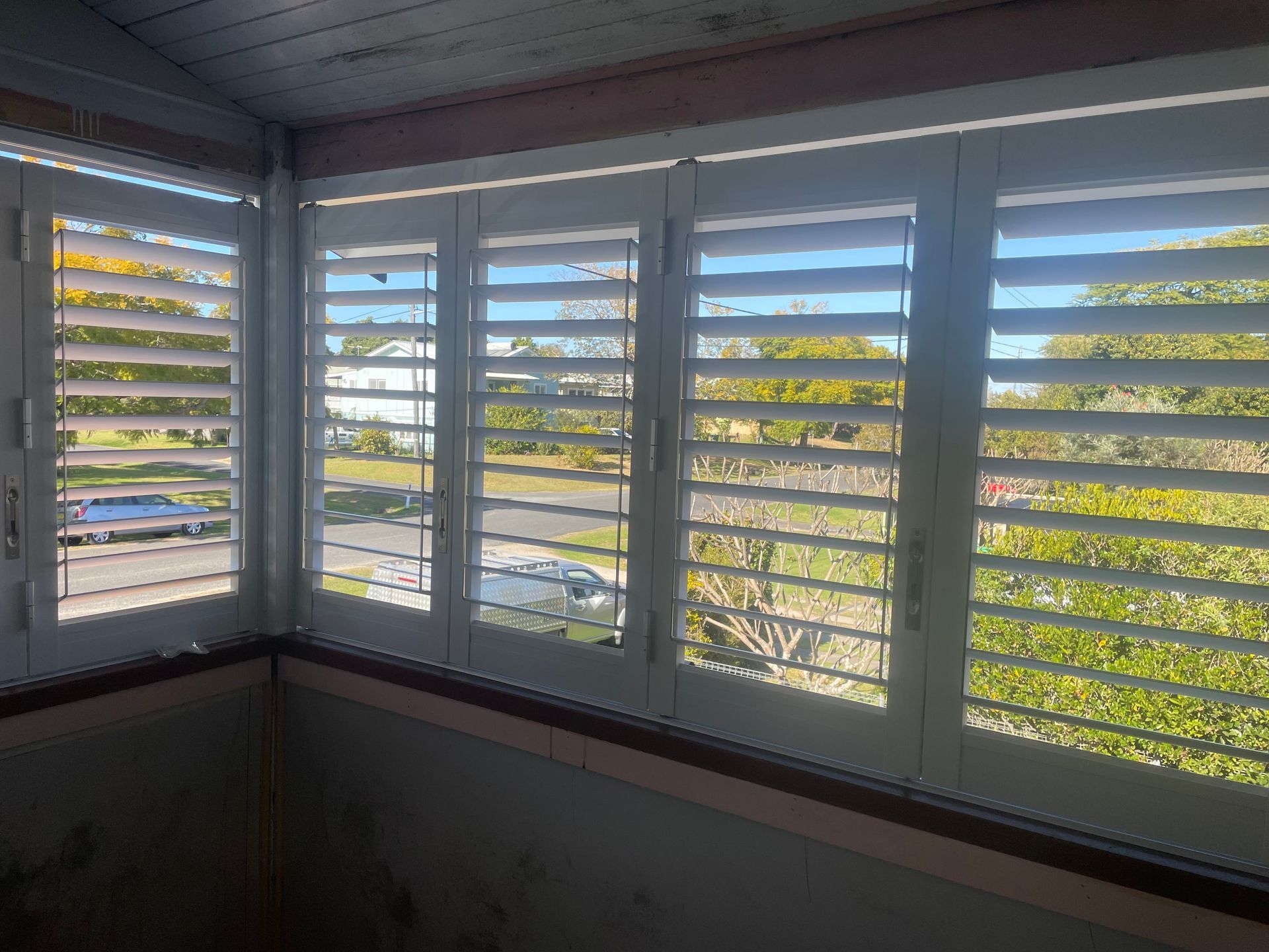 A Man Is Installing Blinds On A Window — Gaeta's Upholstery Blinds & Awnings in Grafton, NSW