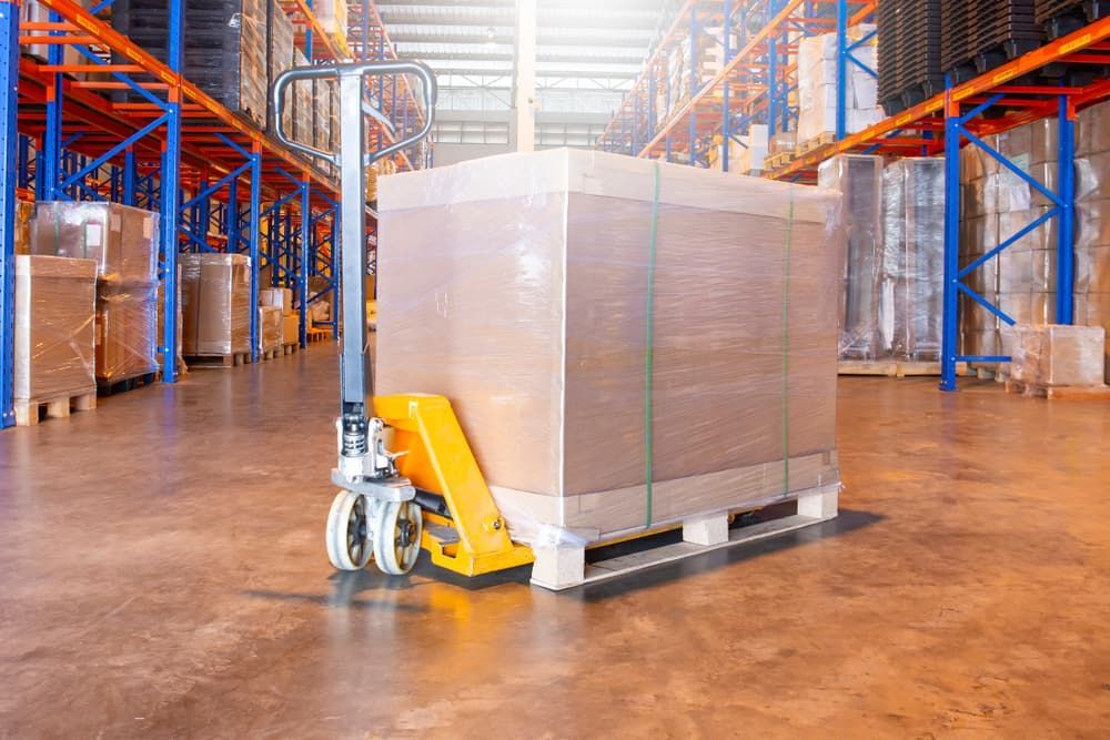A Pallet Jack With a Wrapped Cardboard Box — Cairns Mini Movers In Mount Sheridan, QLD