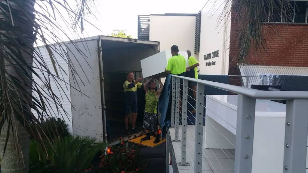 Four Movers Lift a Large White Object — Cairns Mini Movers In Mount Sheridan, QLD