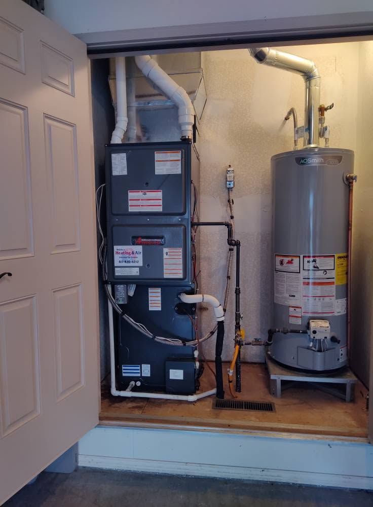 Basement utility closet with furnace, water heater, and pipes behind an open door