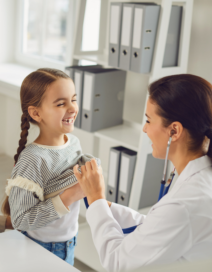 Um médico está ouvindo o peito de uma menina com um estetoscópio.