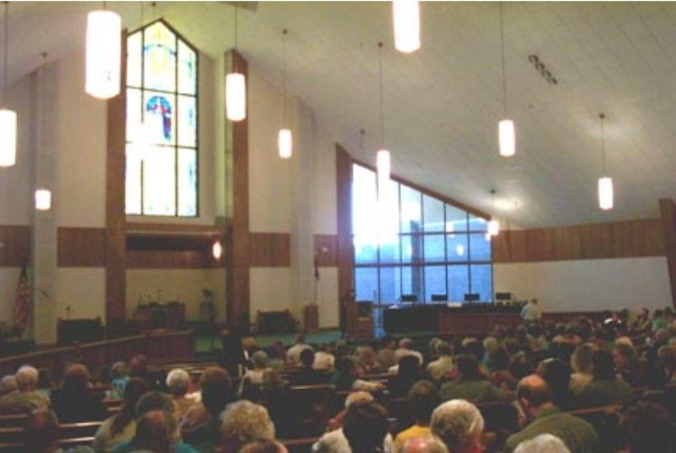 Interior of a church during a service, filled with people facing towards the front