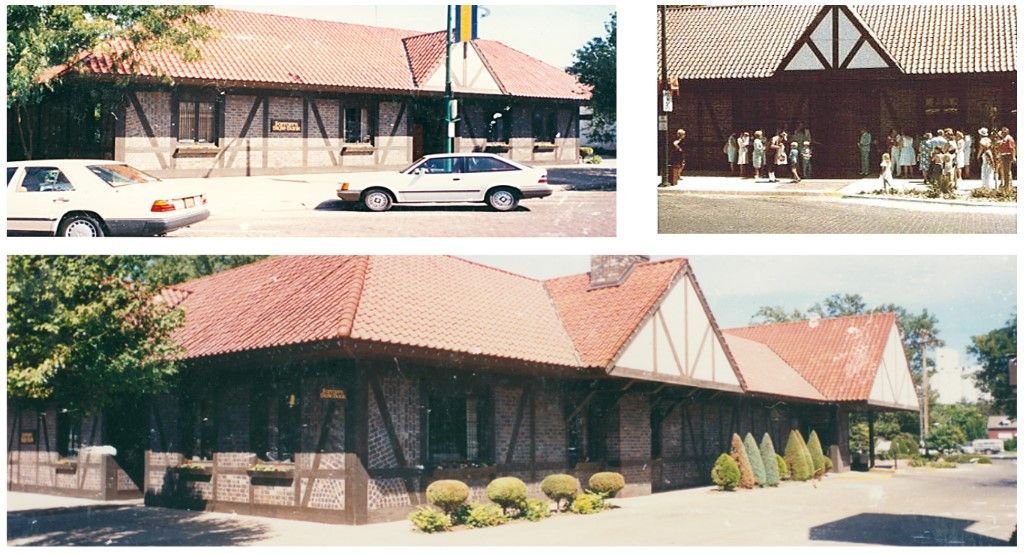 Buildings with red tile roofs and half-timbered walls, likely a restaurant. Cars and greenery in view.
