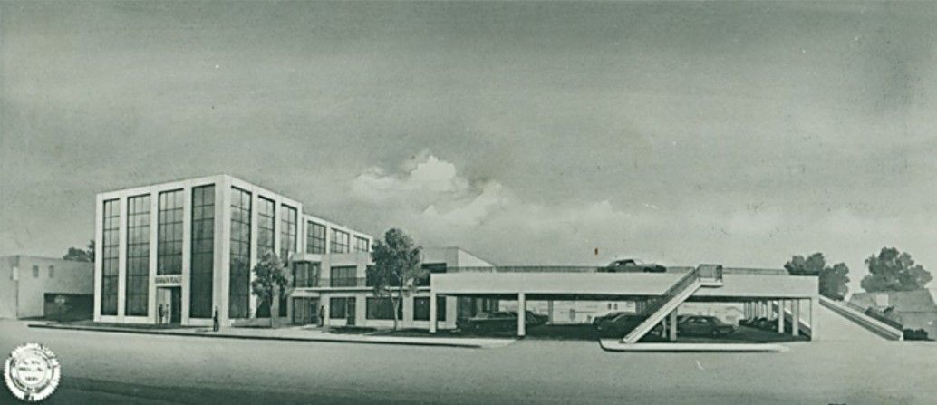 Architectural rendering of a modern building with a long, low wing and a taller, multi-story section.