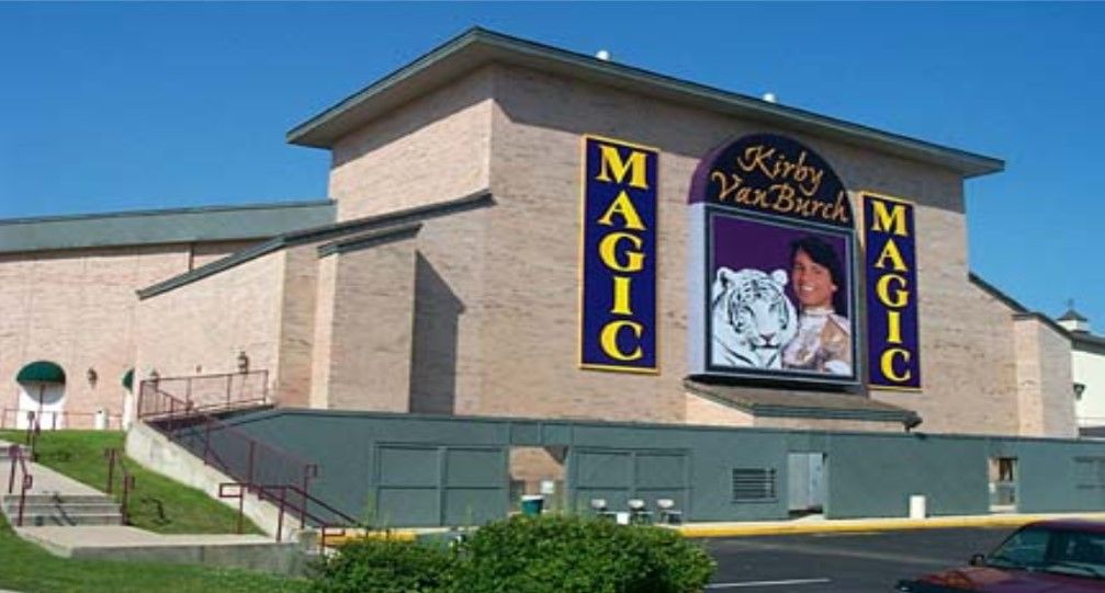 Kirby Van Burch Magic theater exterior, brick building with large signs and a person holding a white tiger.